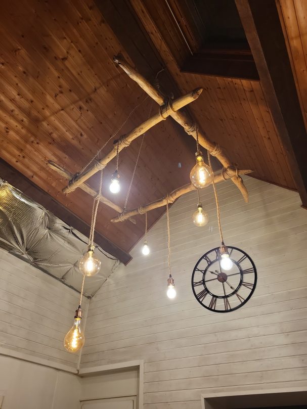 Suspension lumineuse en bois flotté et cordage avec plusieurs ampoules.